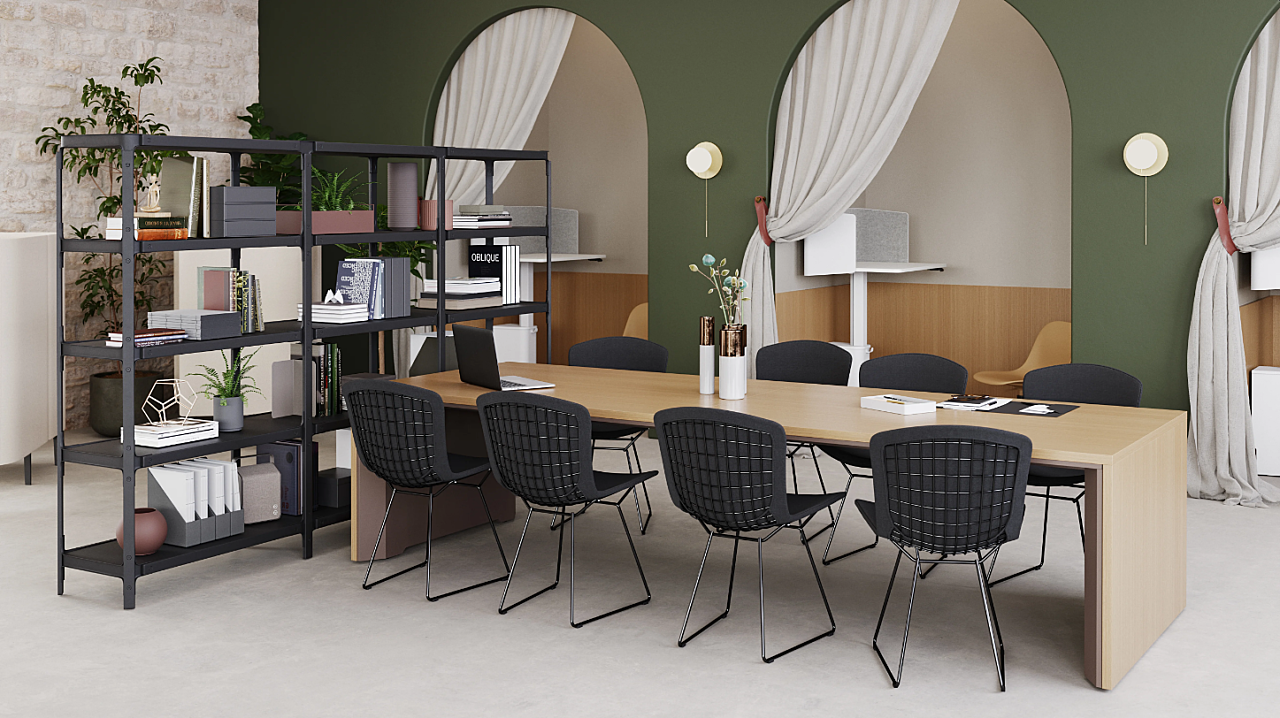 Modern workspace featuring MillerKnoll furnishings, including a sleek conference table, wireframe chairs, and shelving with curated decor and greenery.