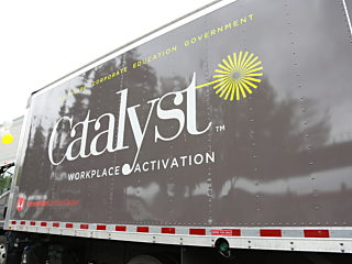 A Catalyst Workplace Activation truck featuring a dark brown exterior with the Catalyst logo on the side.