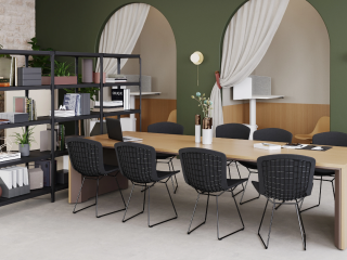 Modern workspace featuring MillerKnoll furnishings, including a sleek conference table, wireframe chairs, and shelving with curated decor and greenery.