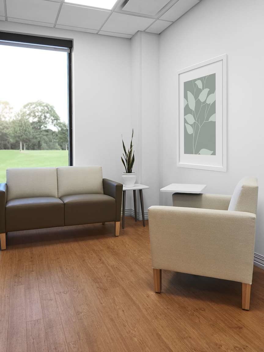 Patient consultation room with beige Nemschoff arm chair, Brown Brava Classic Multiple Seating, Nemschoff Palisade Mobile Table and Palisade Side Table.